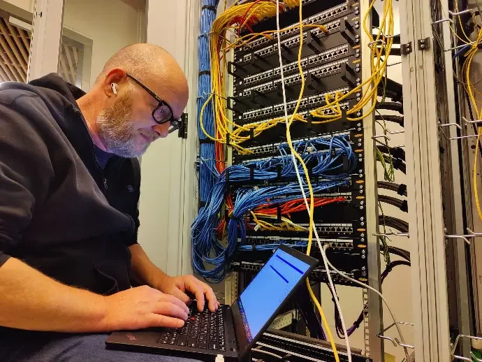 Eelco van XSbyte werkt aan een patchpaneel in de meterkast van een klant